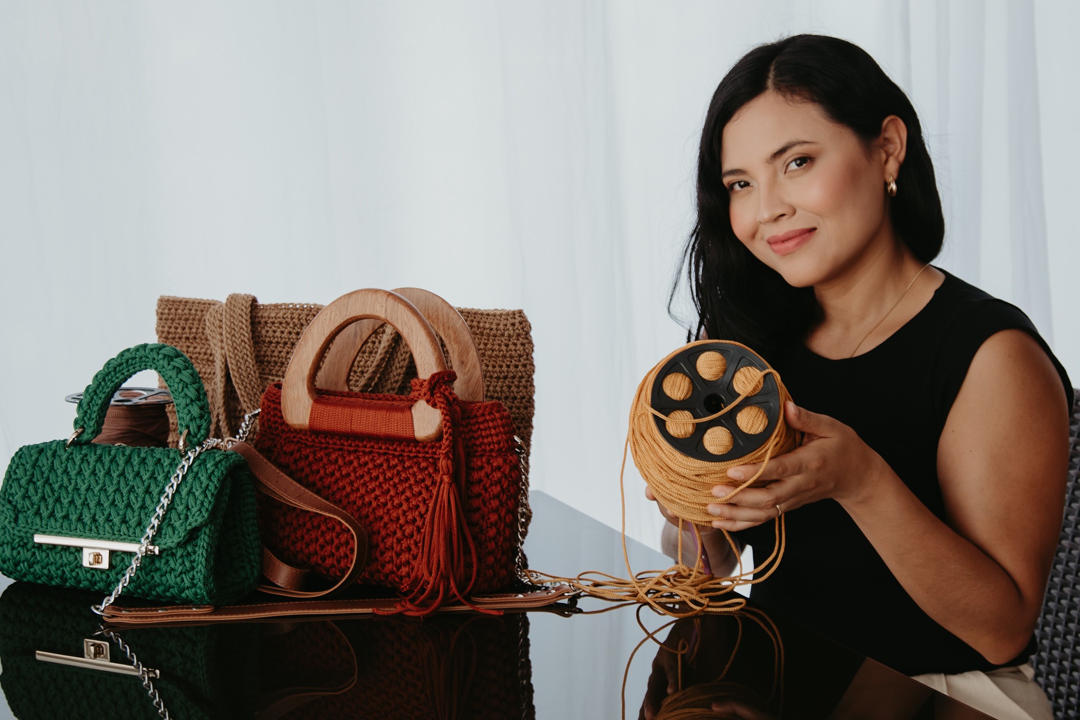 Êdi com bolsas de crochê artesanais e novelo de fio